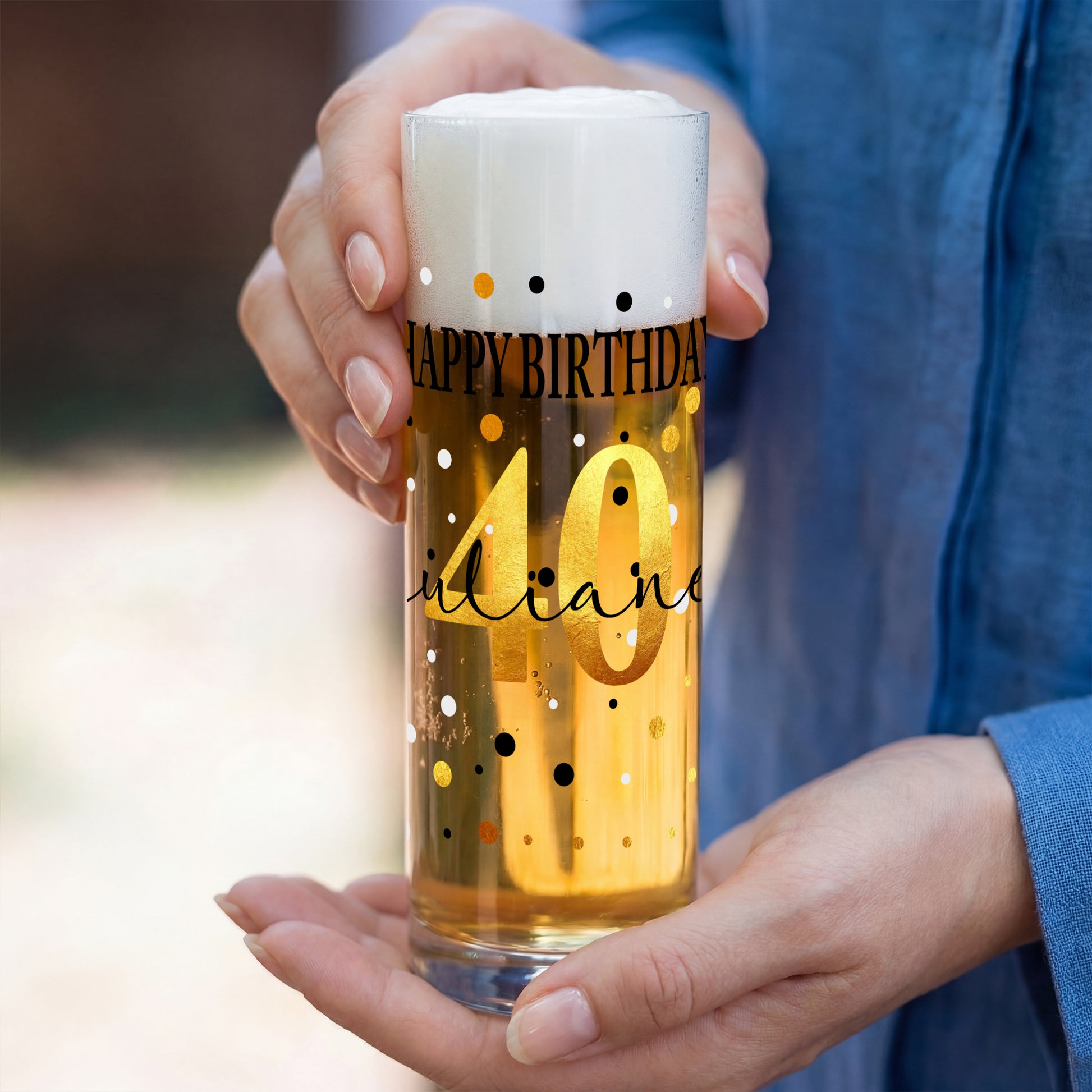 Personalisierte Bierstange zum Geburtstag mit großer goldener Zahl 40, Happy-Birthday-Schriftzug und Name, in zwei Händen präsentiert.