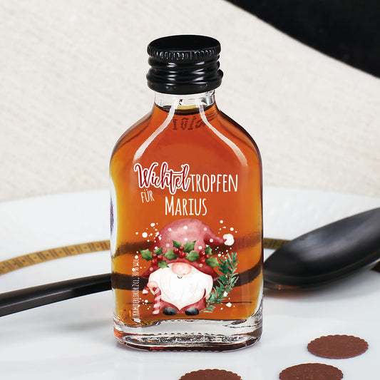Mini-Kräuterlikörflasche mit Wichtelmotiv und Namenspersonalisierung in festlicher Tischszene.