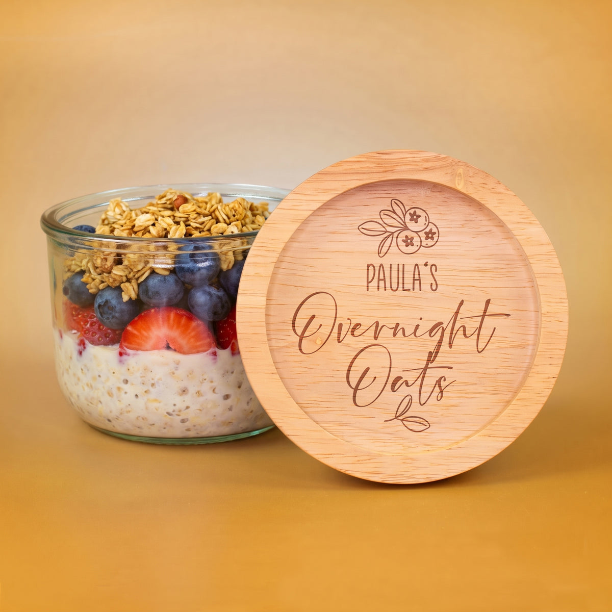 Overnight-Oats-Vorratsglas mit Beeren und Müsli neben graviertem Holzdeckel mit personalisiertem Namen Paula