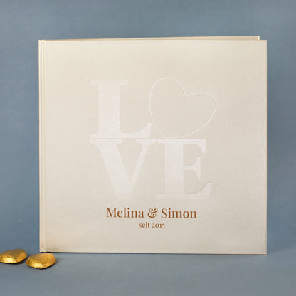 Personalisierbares Gästebuch Hochzeit cremeweiß mit LOVE-Prägung und Herz, Beispielnamen Lisa & Jakob