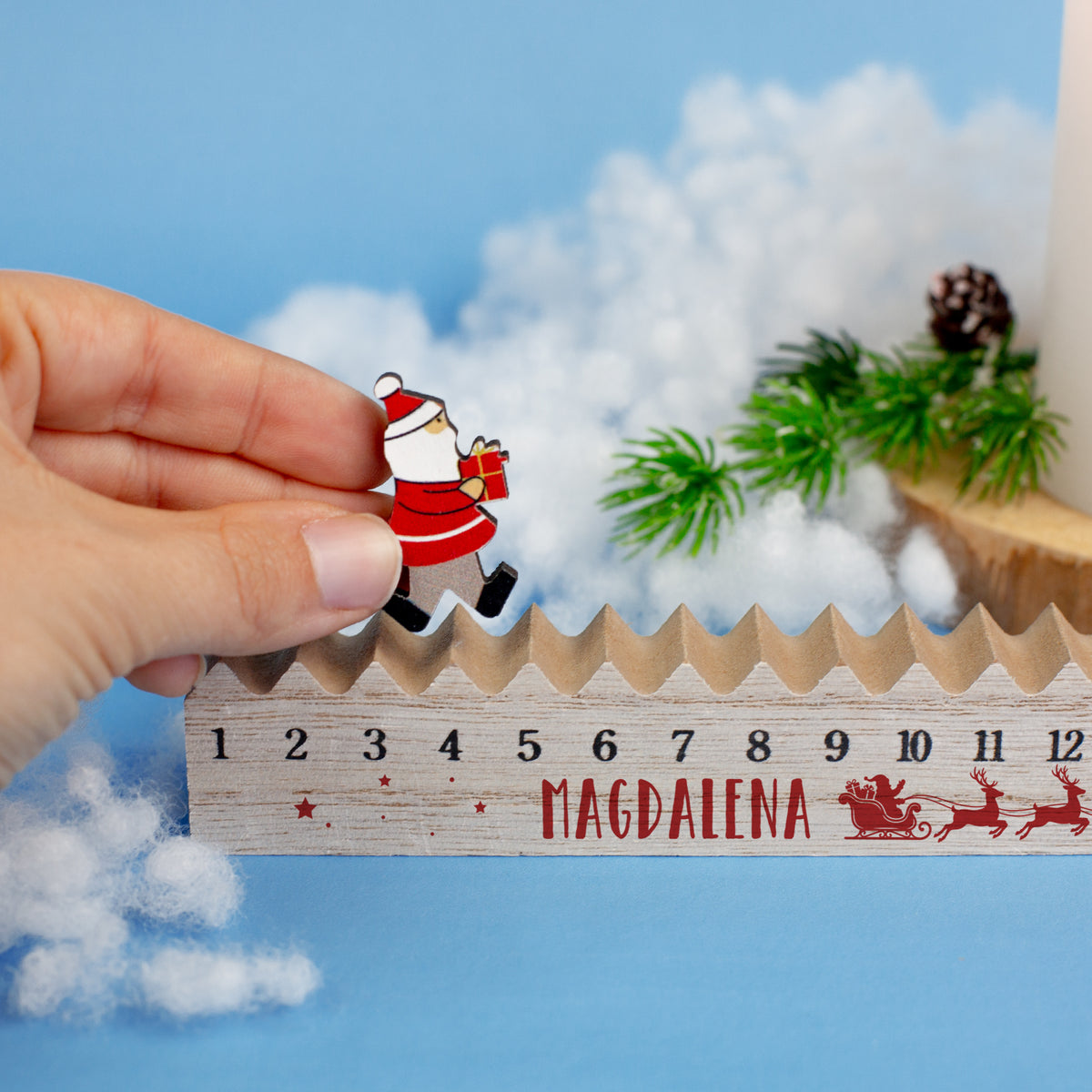 Detailansicht des Adventskalenders mit Name „Magdalena“, während die bewegliche Weihnachtsmann-Figur auf der Holzleiste versetzt wird