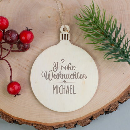 Holzanhänger in Tannenbaum-Form mit Gravur „Frohe Weihnachten Leonie“, dekoriert mit roten Beerenzweigen.