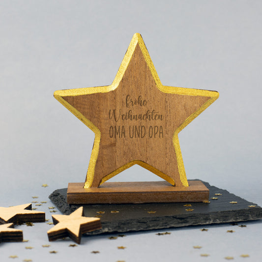Holzstern mit Gravur Frohe Weihnachten und Wunschtext Oma und Opa, goldener Rand, auf Schieferplatte mit Sternkonfetti