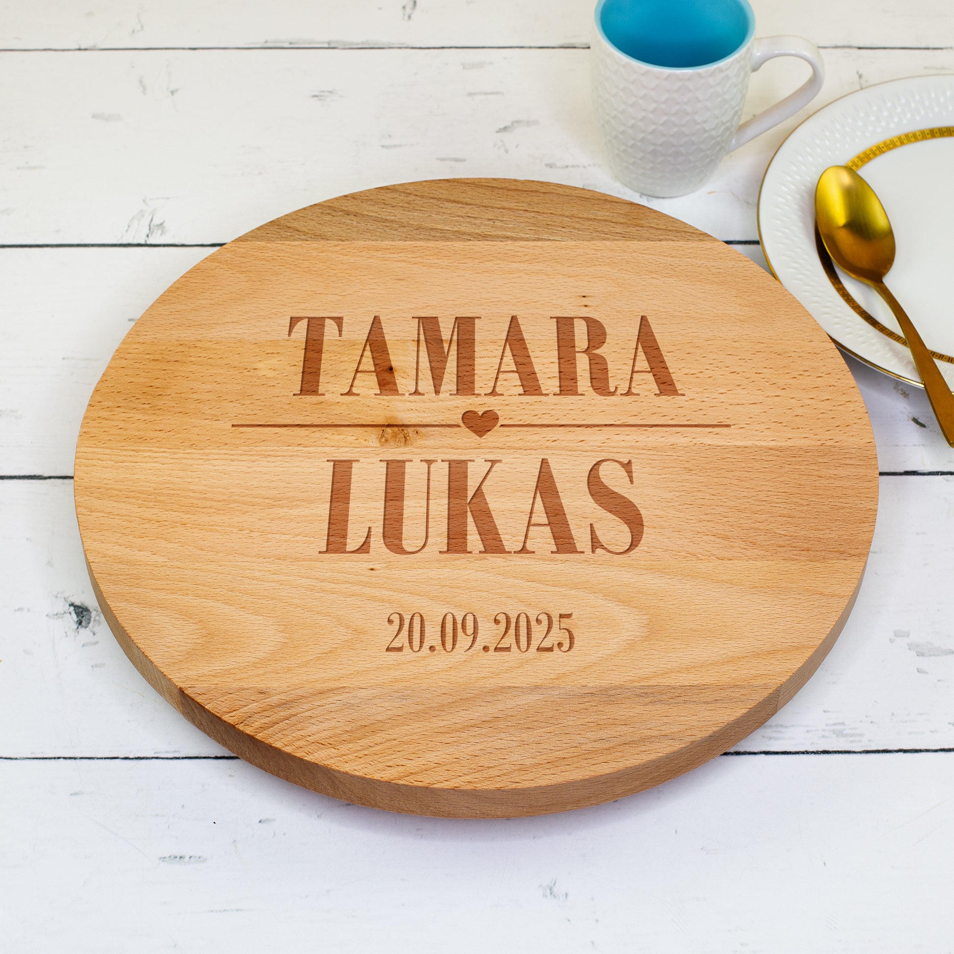 Personalisierte Holz-Tortenplatte mit Gravur „Tamara ♥ Lukas – 20.09.2025“ auf hellweißem Tisch