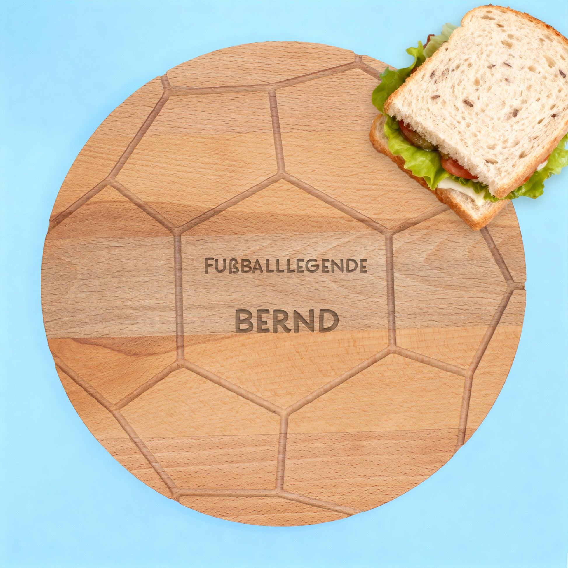 Fußballbrettchen aus Buchenholz mit Gravur „FUSSBALLLEGENDE BERND“ auf blauem Hintergrund