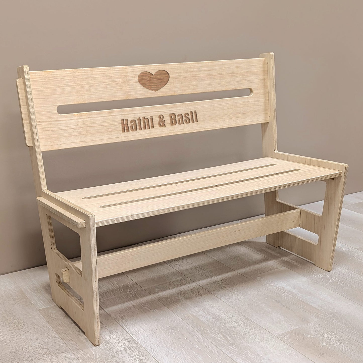 Holzbank mit Gravur „Kathi & Basti“ in Innenraumumgebung – perfekte Geschenkidee zur Hochzeit oder zum Jahrestag