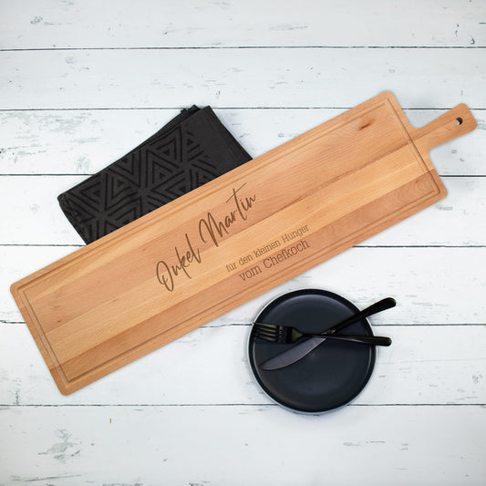 XXXL Servierbrett aus Buchenholz mit Gravur „Onkel Martin – für den kleinen Hunger – vom Chefkoch“ auf weißem Tisch