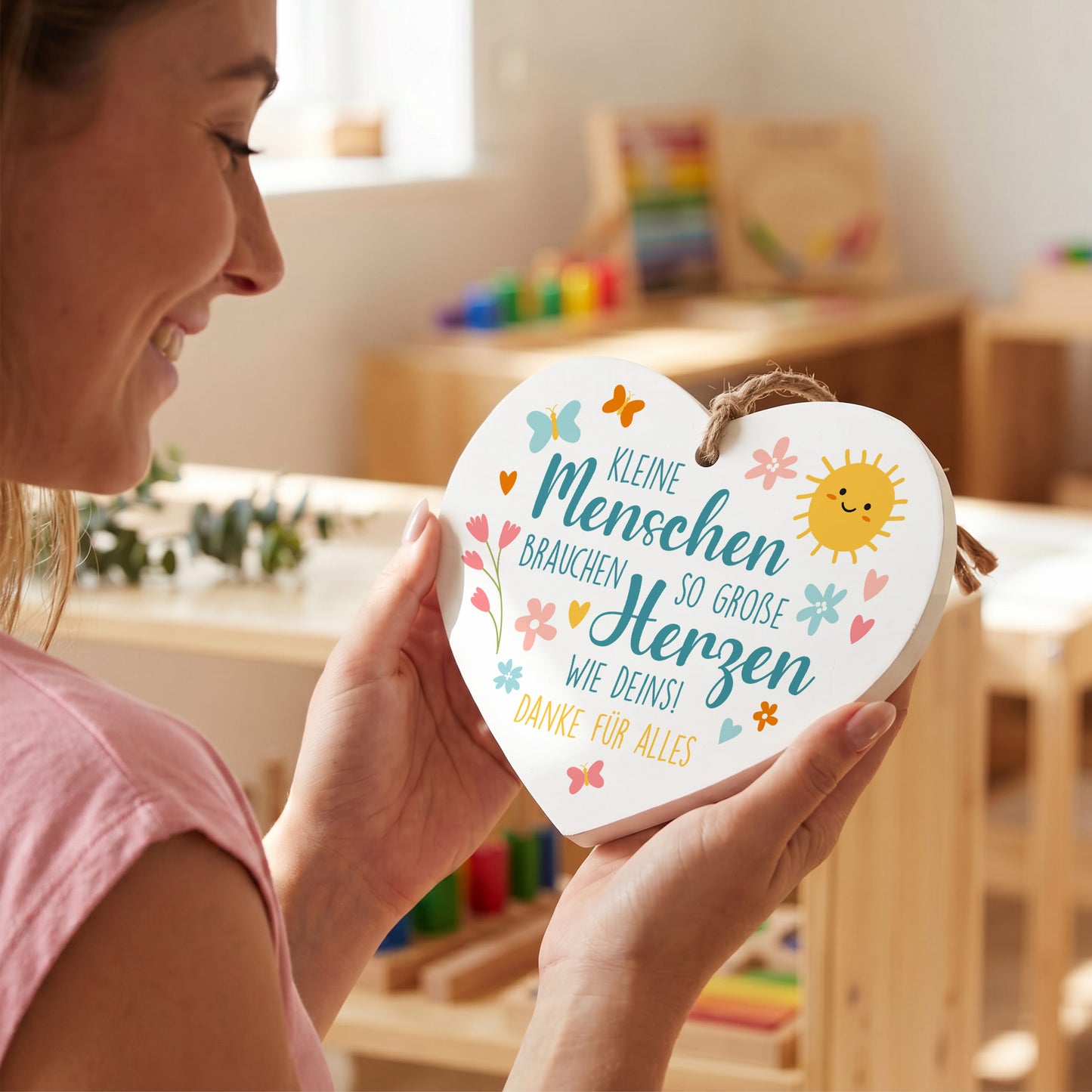 Frau hält personalisiertes Holzherz als Dankeschön Geschenk für Erzieherin mit Wunschtext Danke für alles