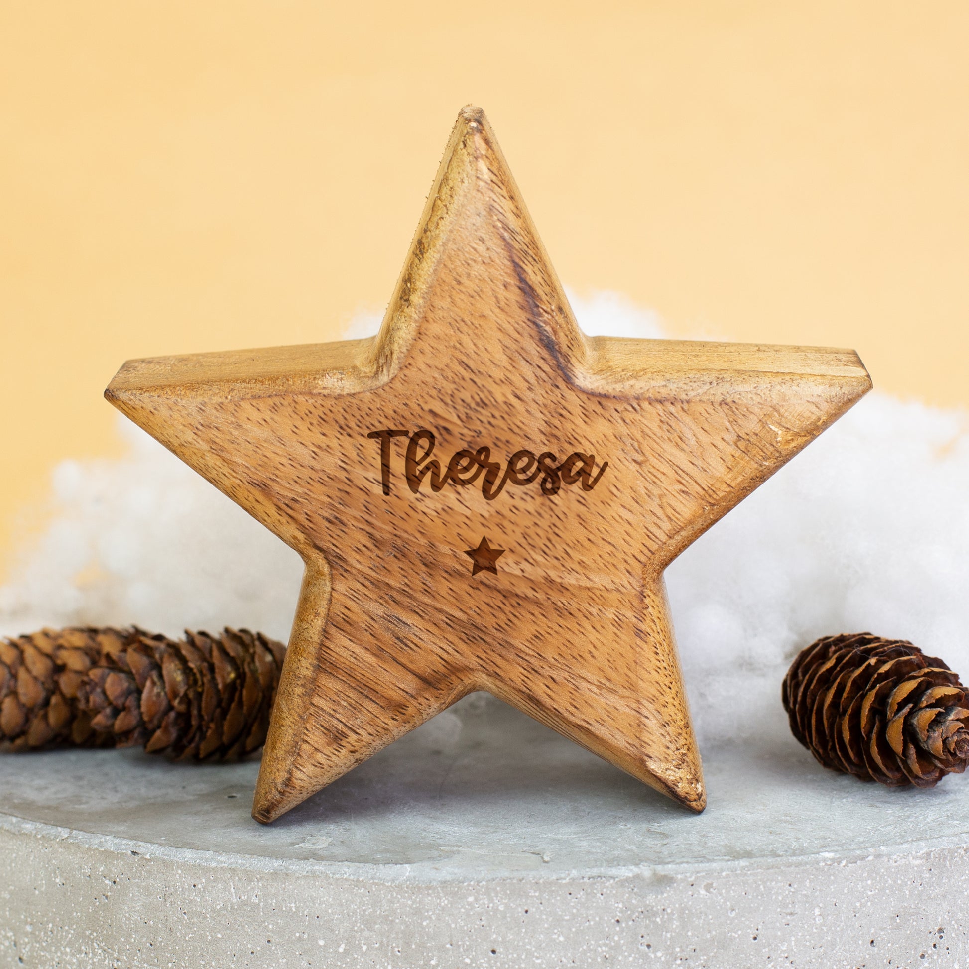 Holzstern mit Gravur „Theresa“ als weihnachtliche Dekoration mit Schneeflocken und Zapfen