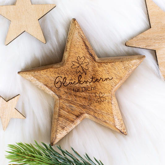 Gravierte Holzdeko „Glücksstern für Dich“ auf weißem Fell mit weiteren Holzsternen
