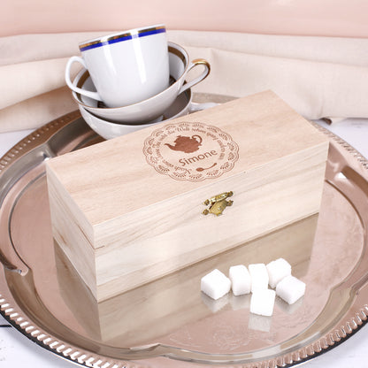 Gravierte Teebox aus Holz mit Spruch „Nach einer Tasse Tee sieht die Welt schon ganz anders aus“ und Name Simone auf silbernem Tablett mit Teetassen.