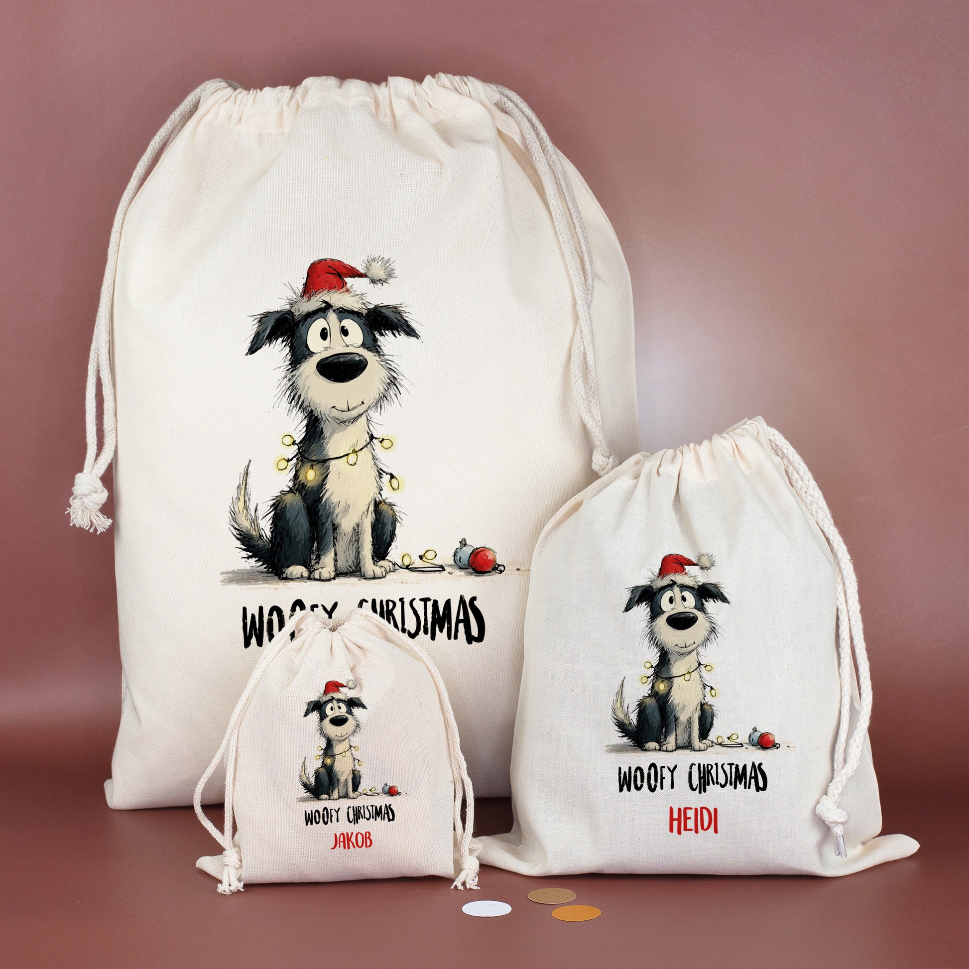 Drei Baumwoll-Geschenksäcke in verschiedenen Größen mit Hundemotiv „Woofy Christmas“, personalisiert mit Namen Jakob, Heidi und Michael