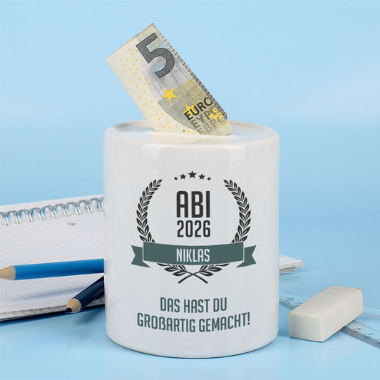 Persönliche Spardose als Geldgeschenk zum Abitur mit Geldschein vor blauem Hintergrund