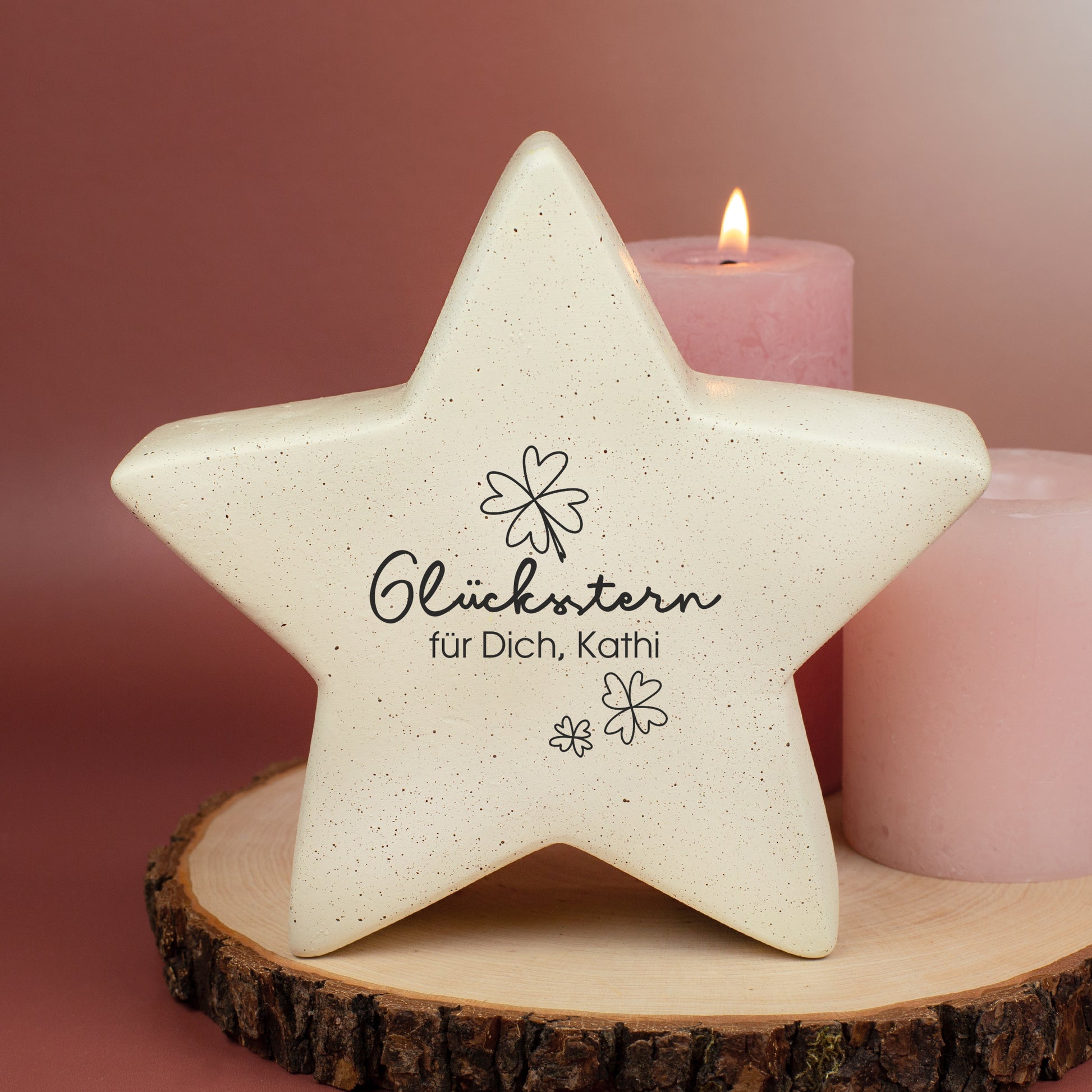 Glücksstern auf Holzscheibe zwischen Kerzen, personalisiert mit Wunschtext