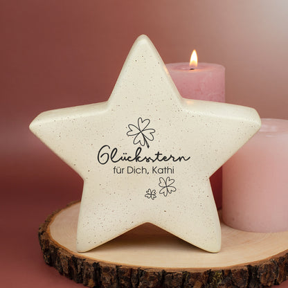 Glücksstern auf Holzscheibe zwischen Kerzen, personalisiert mit Wunschtext
