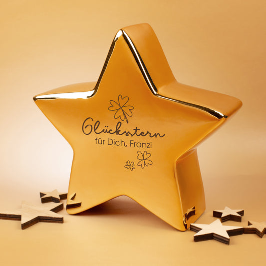 Goldfarbener Keramikstern von Leonardo mit Glücksstern-Motiv und personalisiertem Text, dekoriert mit Holzsternen