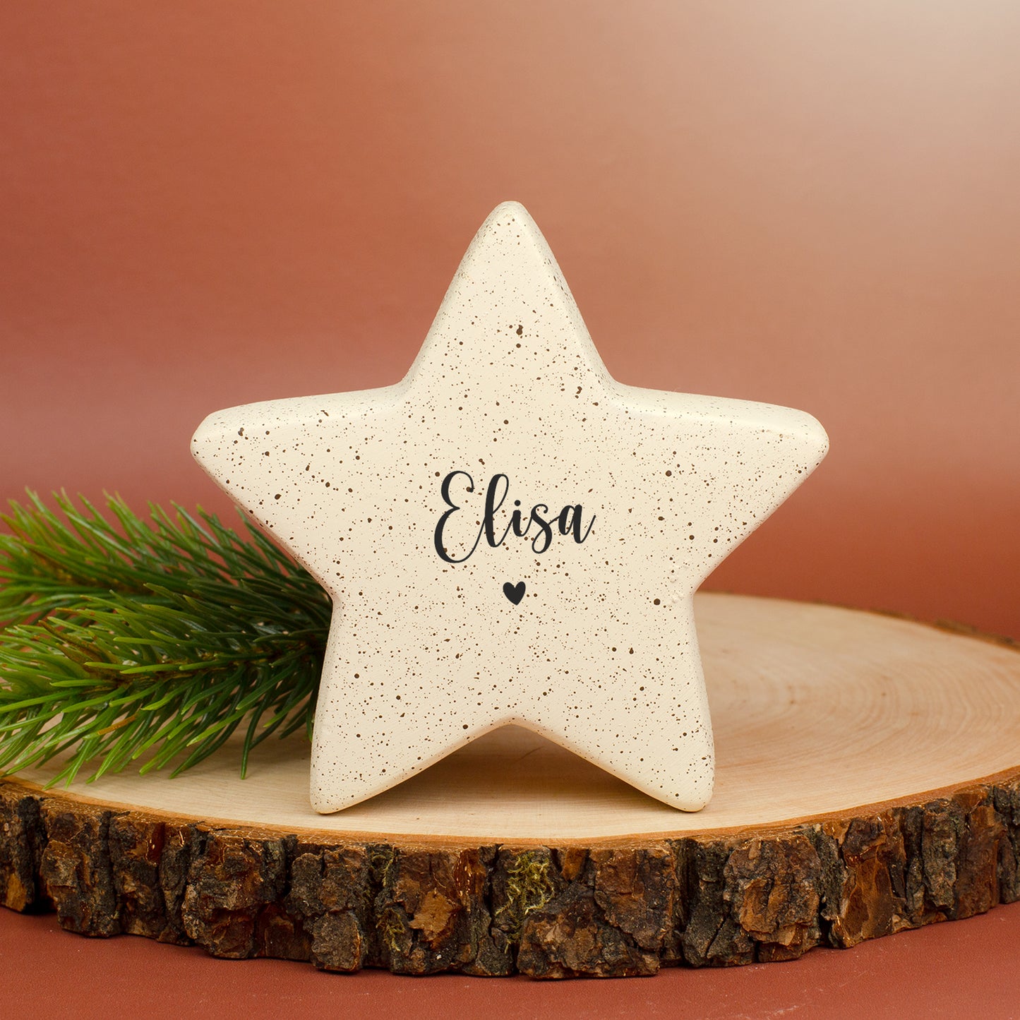 Freigestellter kleiner Keramikstern in Creme mit Namensaufdruck „Elisa“ und Herzsymbol.