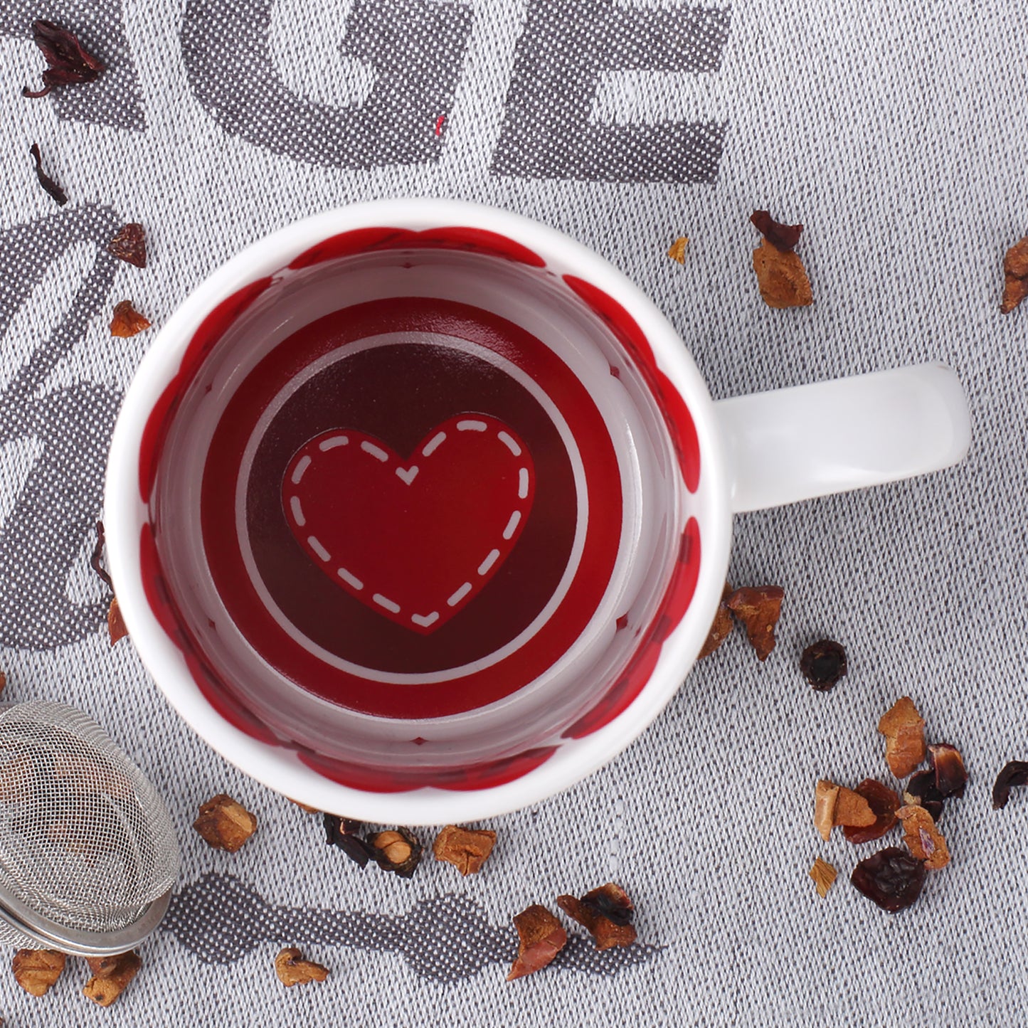 Blick in die Tasse mit rotem Herzdesign und Love-Schriftzügen innen am Tassenrand zum Valentinstag