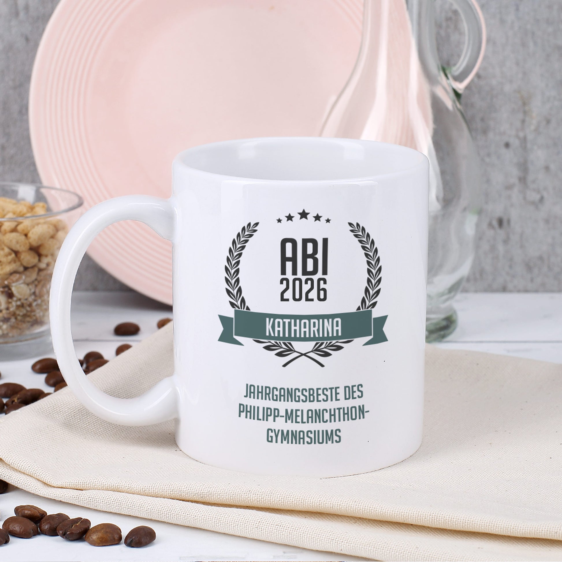 Glückwunsch-Tasse zum Abitur mit Name und Wunschtext dekoriert auf Serviette