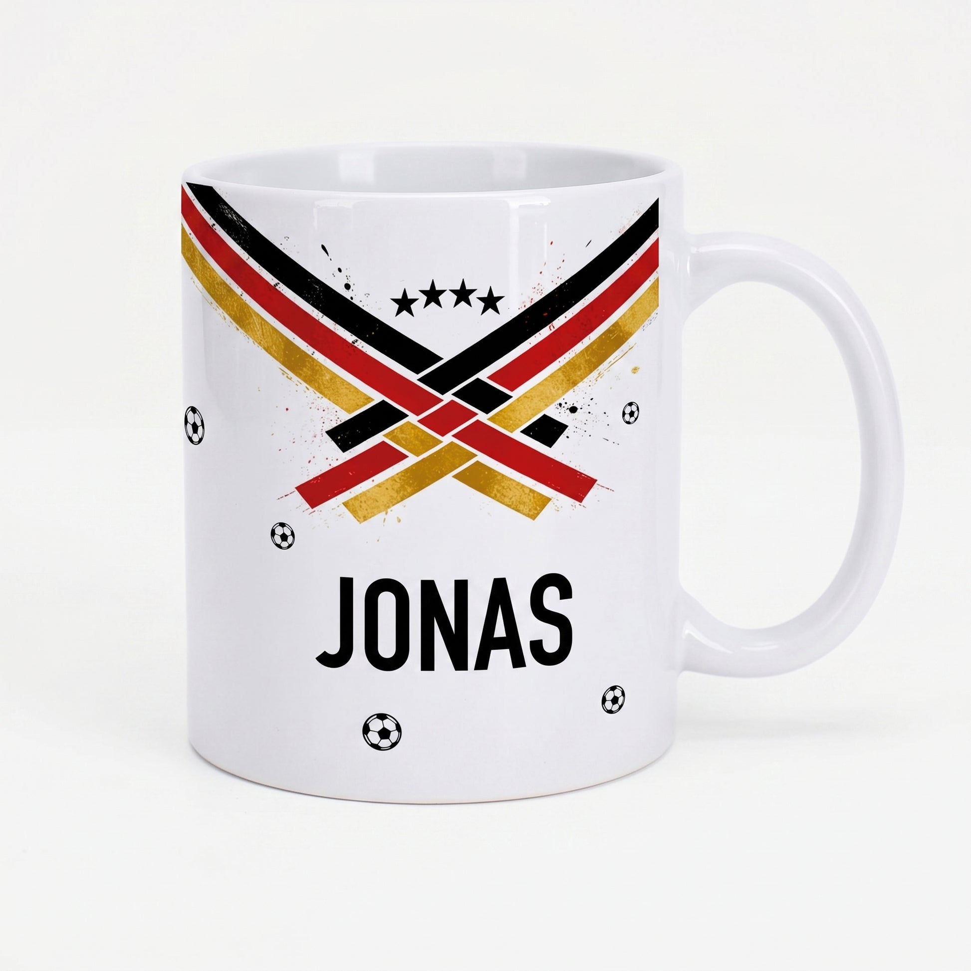 Weiße Fußball Tasse mit Name Jonas, schwarz-rot-goldenem Streifenmotiv, Sternen und kleinen Fußbällen auf hellem Hintergrund