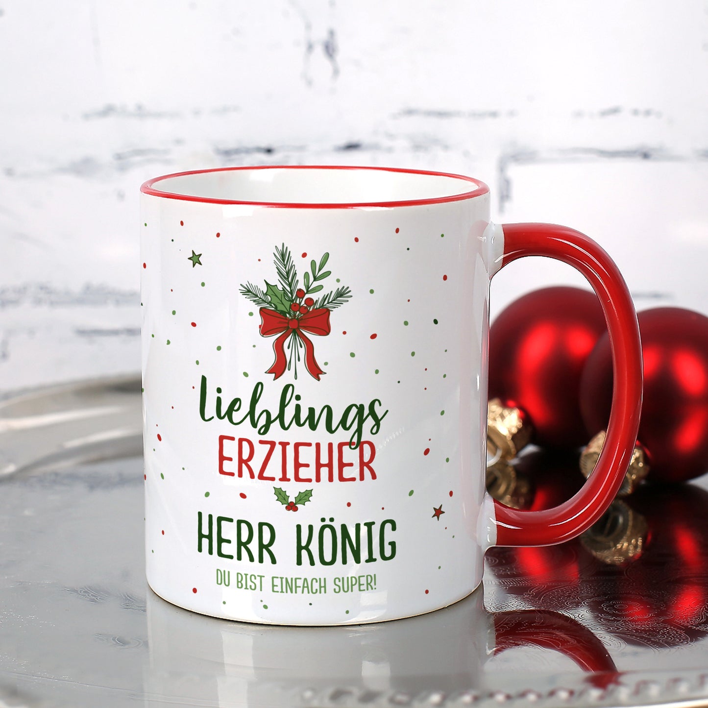 Personalisierte Weihnachtstasse für Erzieher mit rotem Henkel und weihnachtlichen Ornamenten.