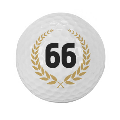 Freigestellter Golfball mit Zahl 66 im goldenen Lorbeerkranz auf weißem Hintergrund