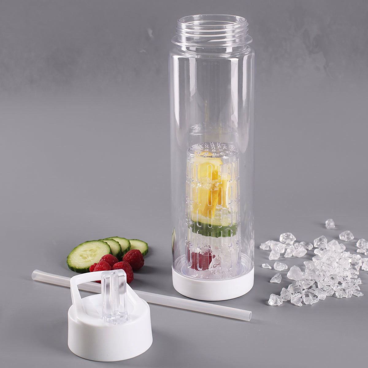 Transparente Trinkflasche mit eingesetztem Fruchteinsatz, Zitrone, Gurke und Himbeeren sowie abgenommenem Trinkverschluss und Trinkhalm
