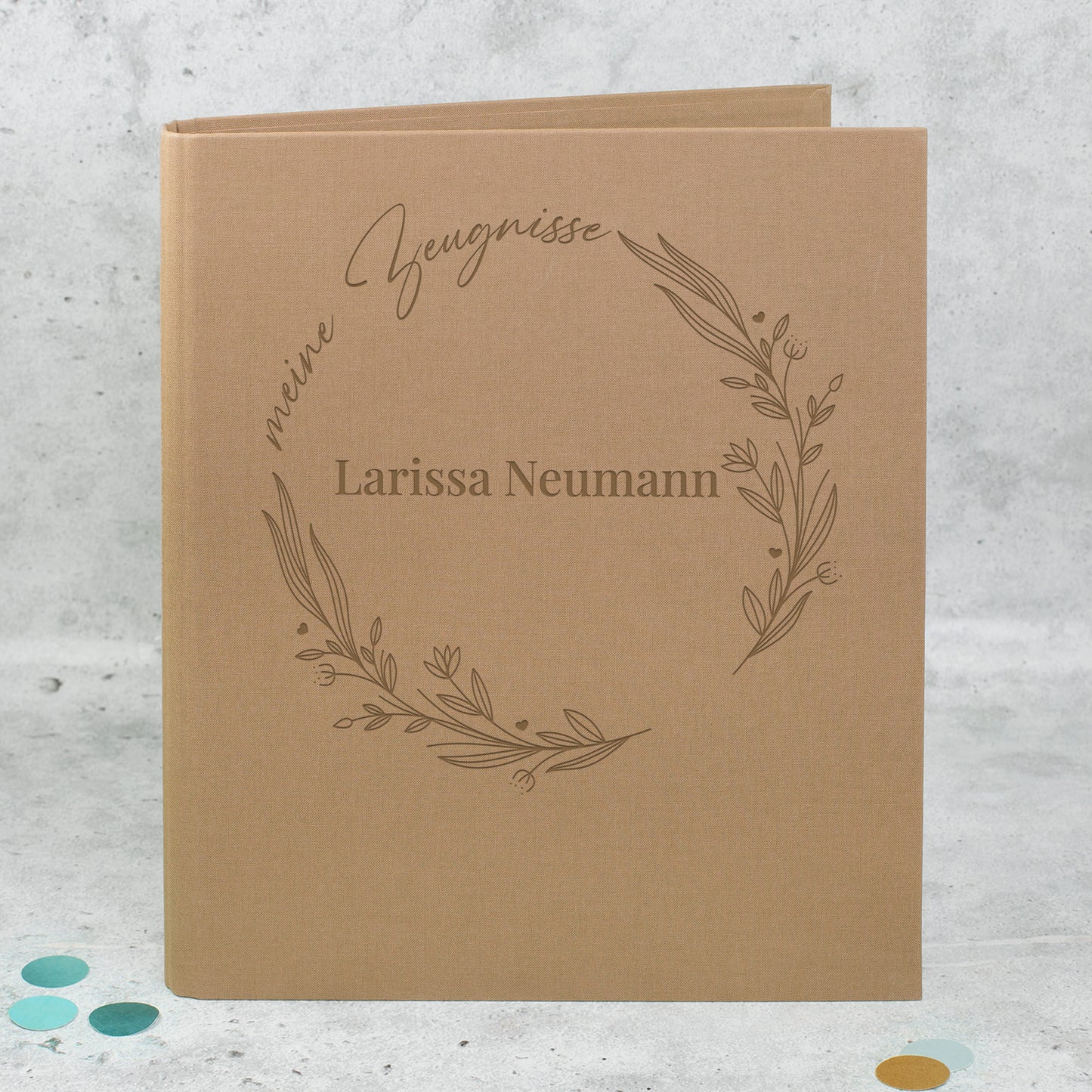 Braune Zeugnismappe aus Leinen mit floralem Lineart-Ring, Aufdruck „meine Zeugnisse“ und personalisiertem Namen „Larissa Neumann“.