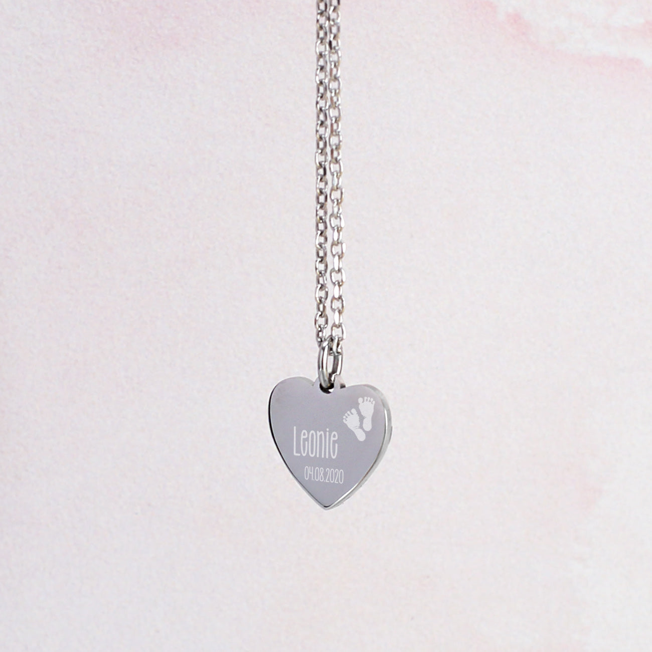 Nahaufnahme der silbernen Leonardo Herzkette zur Geburt mit Name und Datum des Babys graviert
