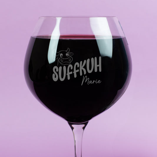 Detailaufnahme des Leonardo Burgunderglases mit Gravur „Suffkuh“ und Name Marie – Gravur mit Kuh-Motiv und Schriftzug auf der Glasoberfläche, gefüllt mit Rotwein.