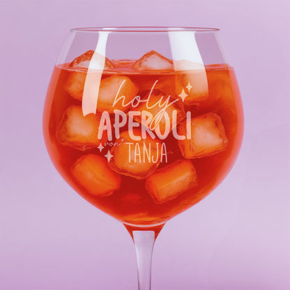Nahaufnahme der Gravur „holy aperoli von Tanja“ auf gefülltem Weinglas mit Eiswürfeln – feine Lasergravur mit verspieltem Schriftzug und Sternmotiven.