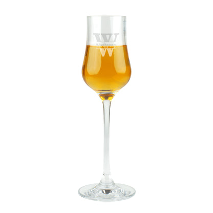 Freigestellte Studioaufnahme des Leonardo Grappaglases mit Gravur „Wolfgang“ und goldfarbenem Inhalt.