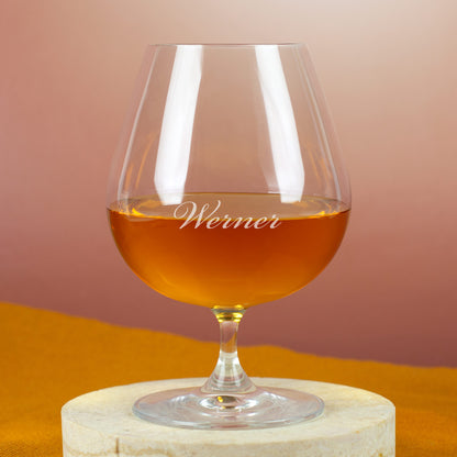 Leonardo Cognacschwenker mit Gravur „Werner“ – gefüllt mit goldbraunem Cognac, auf hellem Steinuntergrund.