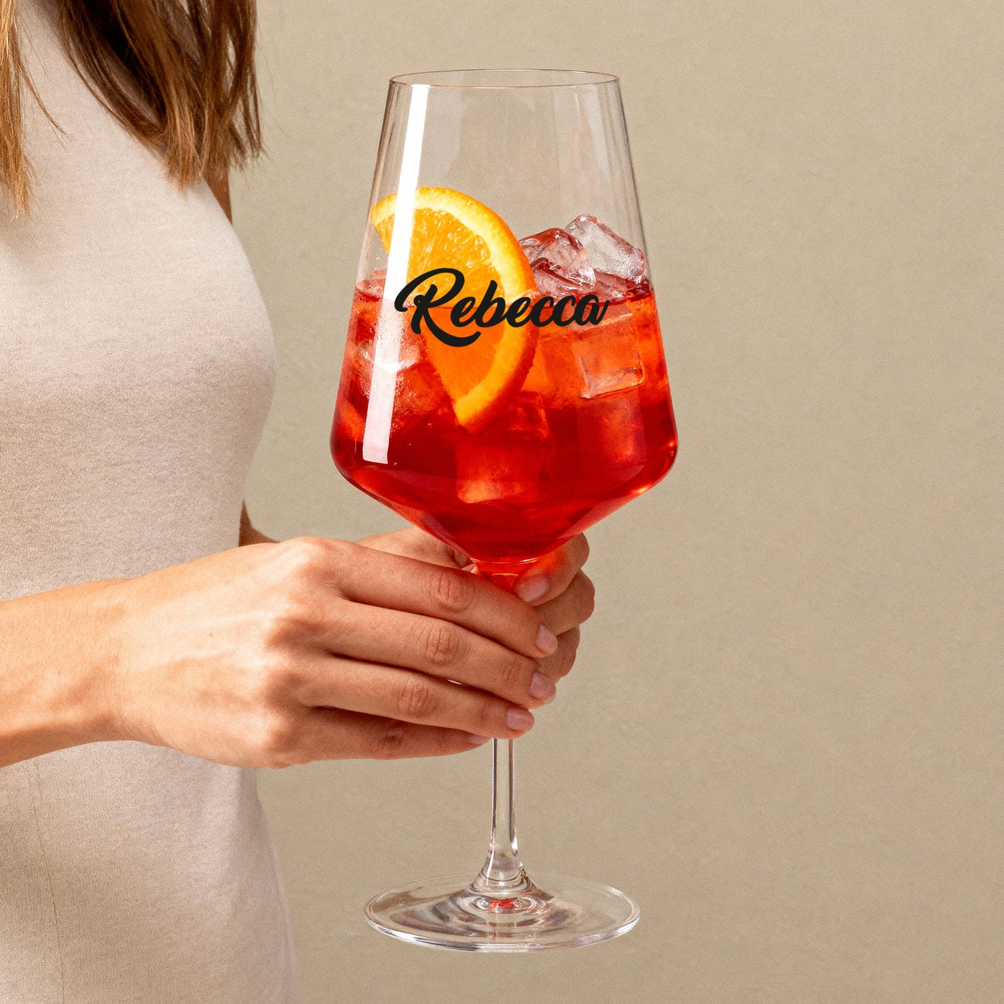 Personalisiertes Leonardo Weinglas mit Namensdruck, gefüllt mit rotem Getränk, in der Hand gehalten