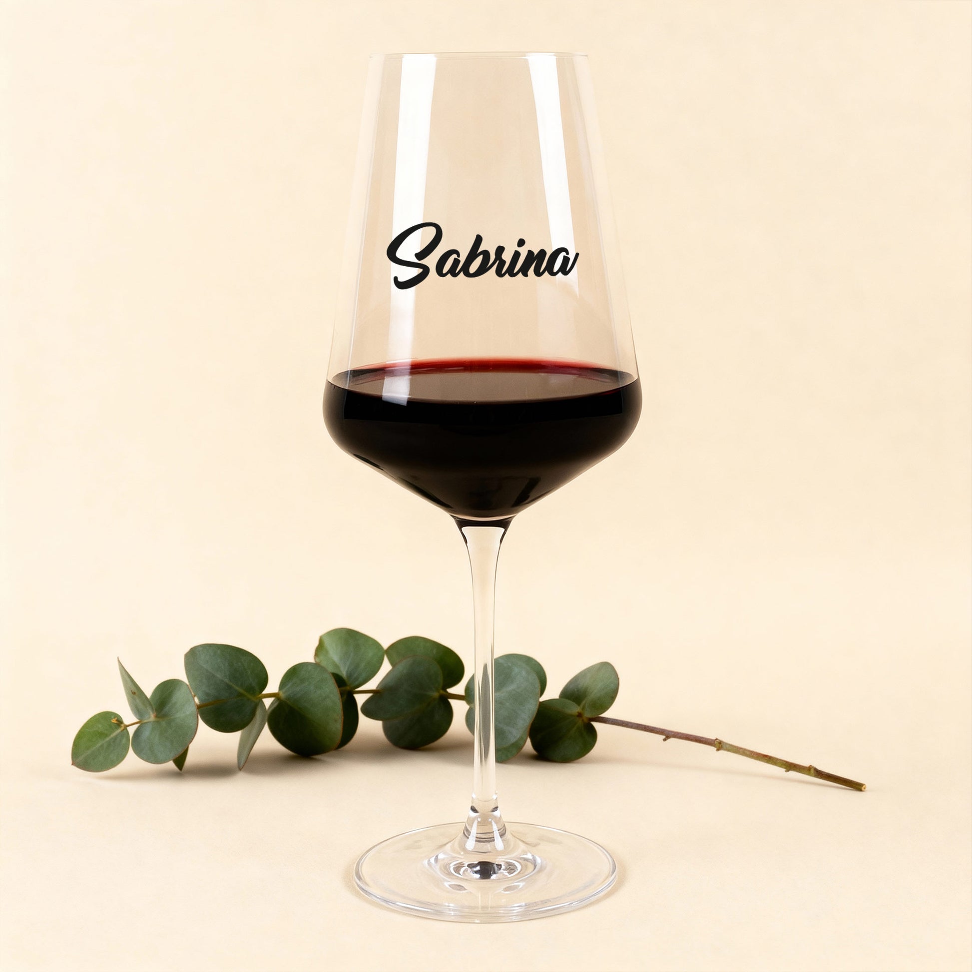 Leonardo Weinglas Puccini mit schwarzem Namensdruck, gefüllt mit Rotwein, vor hellem Hintergrund