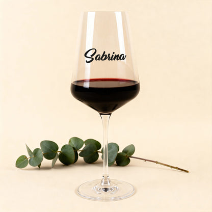 Leonardo Weinglas Puccini mit schwarzem Namensdruck, gefüllt mit Rotwein, vor hellem Hintergrund