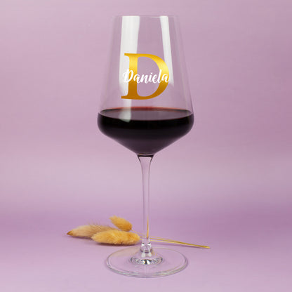 Personalisierbares Weinglas von Leonardo mit Initiale D und Name Daniela vor pastellfarbenem Hintergrund