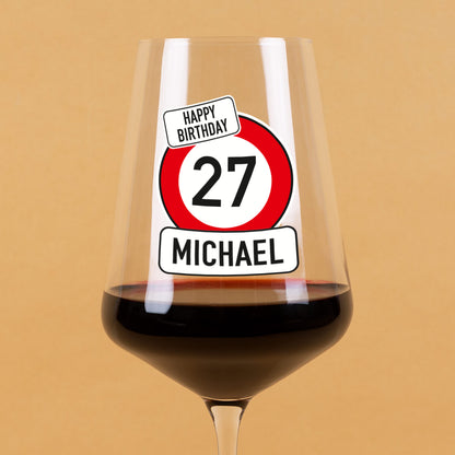 Detailansicht vom Weinglas mit Happy-Birthday-Verkehrszeichen und personalisiertem Alter