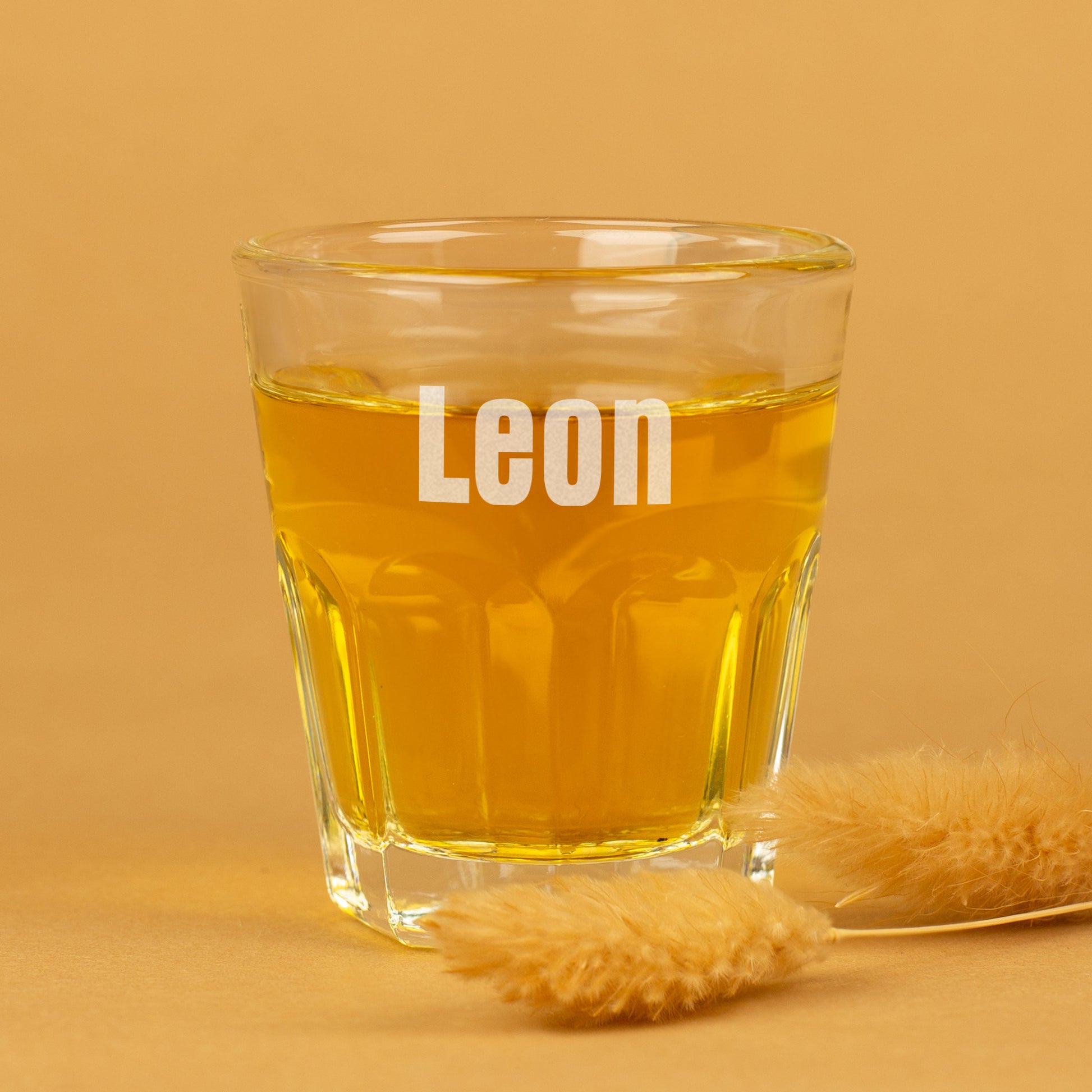 Leonardo Schnapsglas mit Namensgravur Leon vor gelbem Hintergrund
