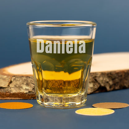Personalisiertes Leonardo Schnapsglas mit Gravur Daniela und Holzdeko im Hintergrund