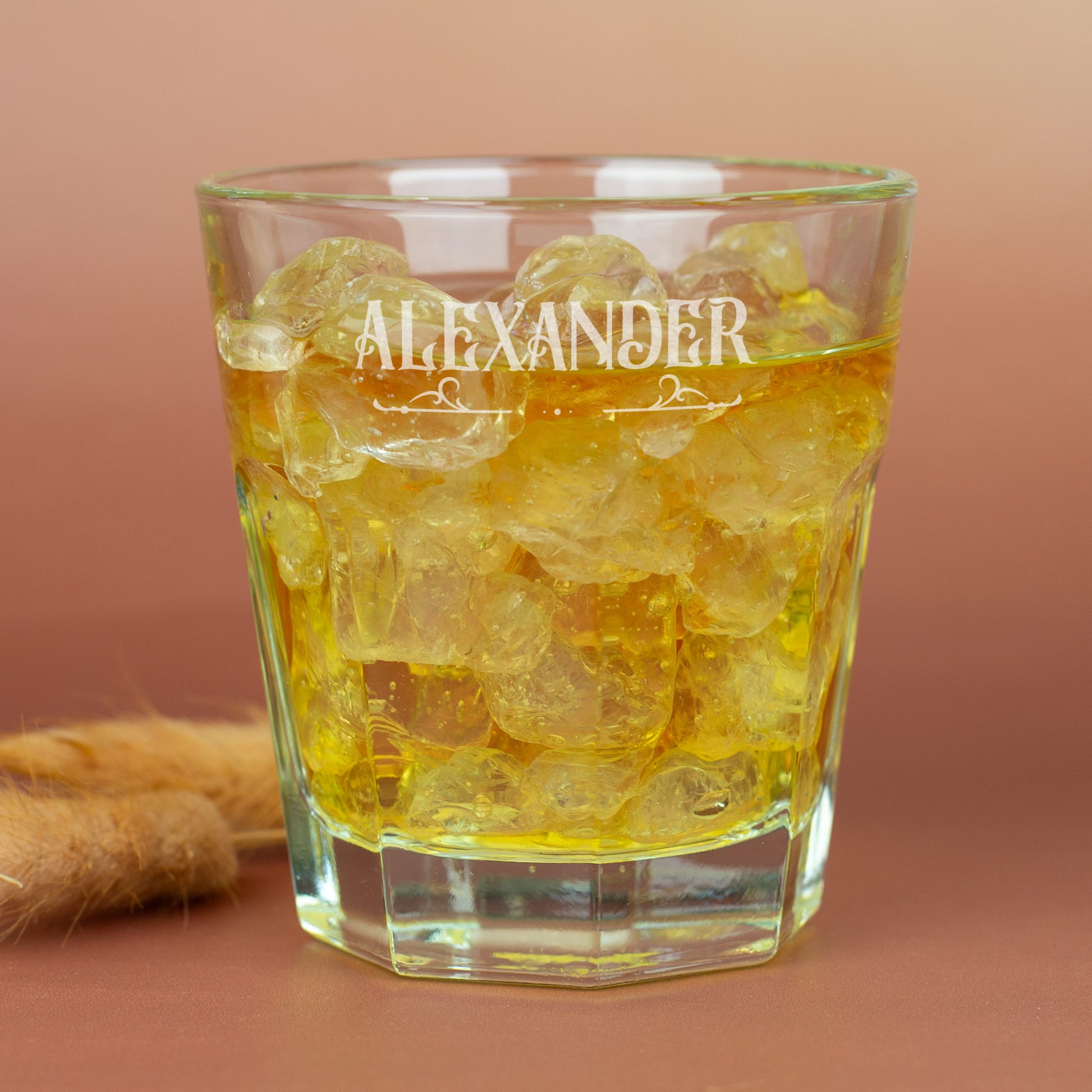 Personalisiertes Leonardo-Glas mit Namensgravur und Ornamentverzierung, goldfarbenes Getränk auf braunem Hintergrund