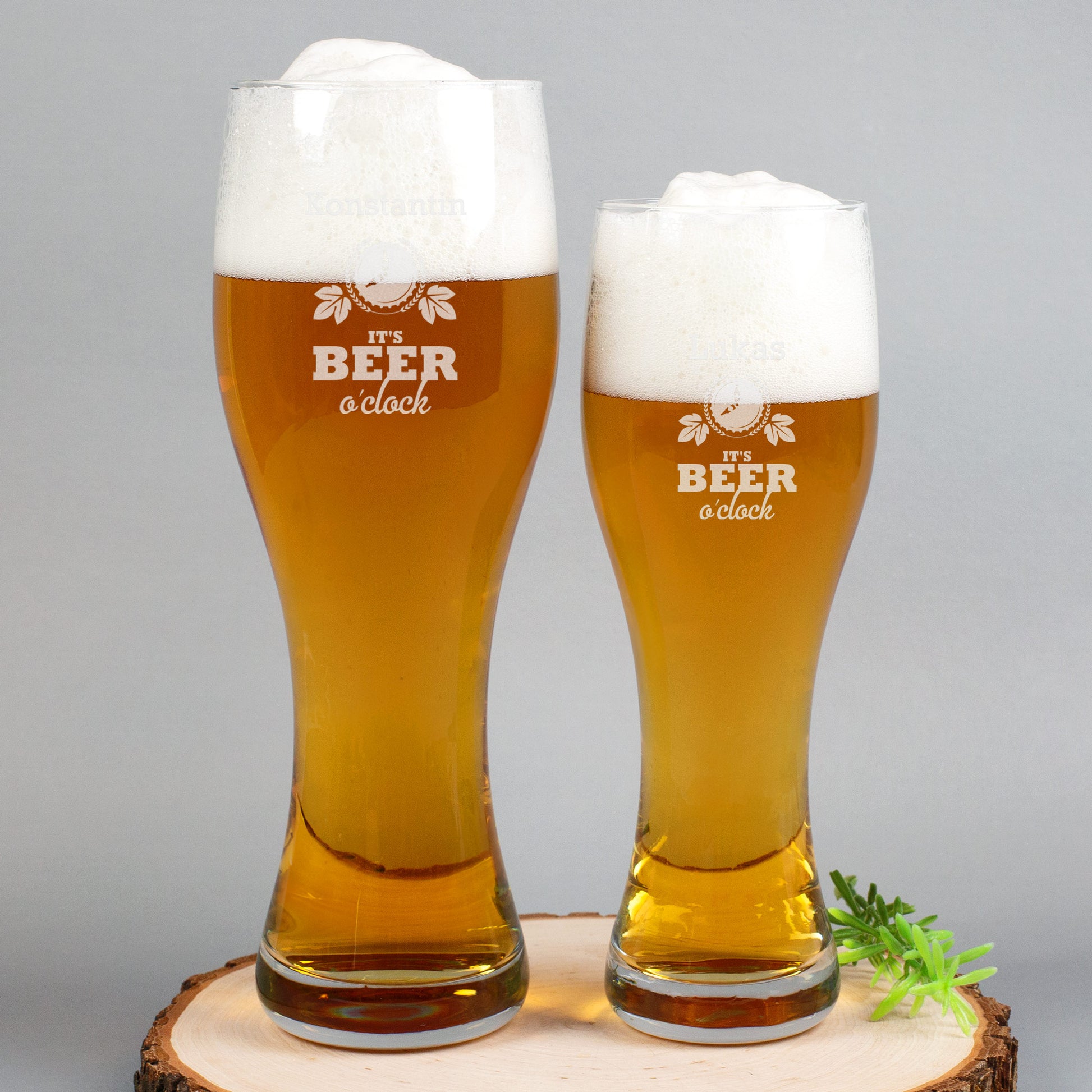 Zwei unterschiedlich große Weizengläser von Leonardo mit Gravur „It’s Beer o’clock“, beide mit Schaumkrone gefüllt
