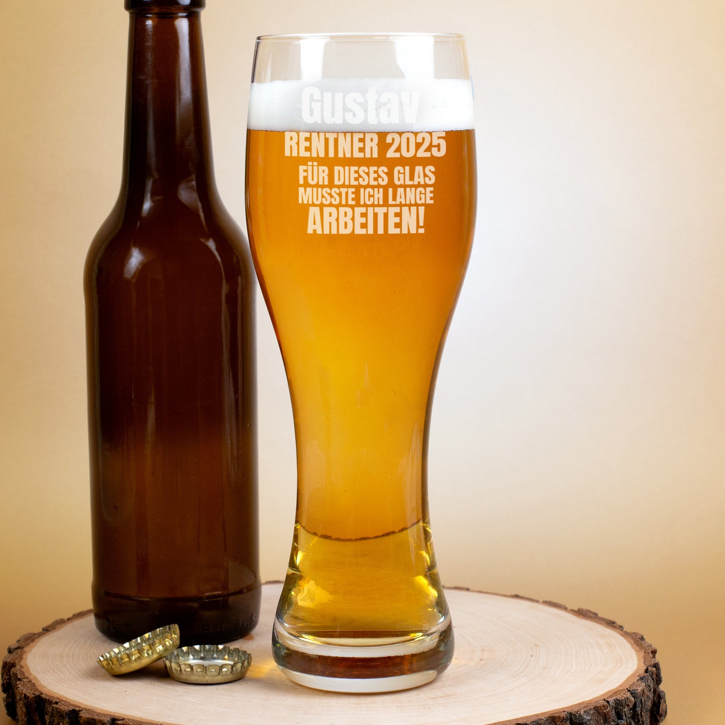 Bierglas mit Gravur „Gustav Rentner 2025“ und Flasche daneben auf Holzunterlage