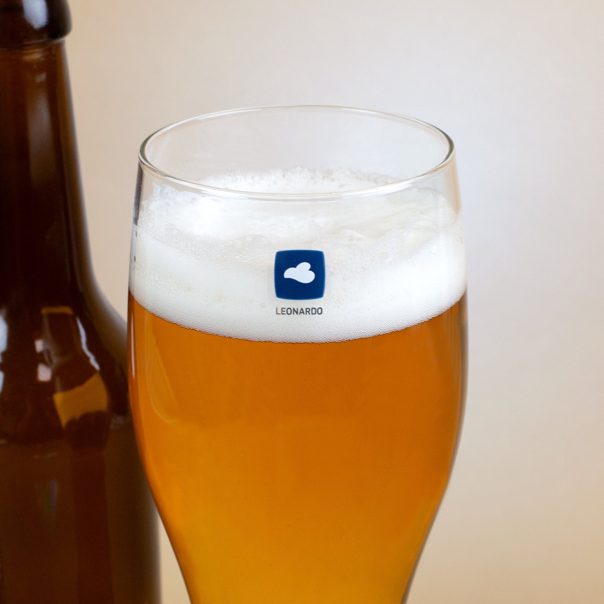 Detailaufnahme Weizenglas mit Leonardo-Logo und Schaumkrone