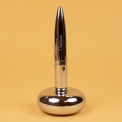 Magischer Kugelschreiber mit Namensgravur stehend in Ständer auf gelbem Hintergrund