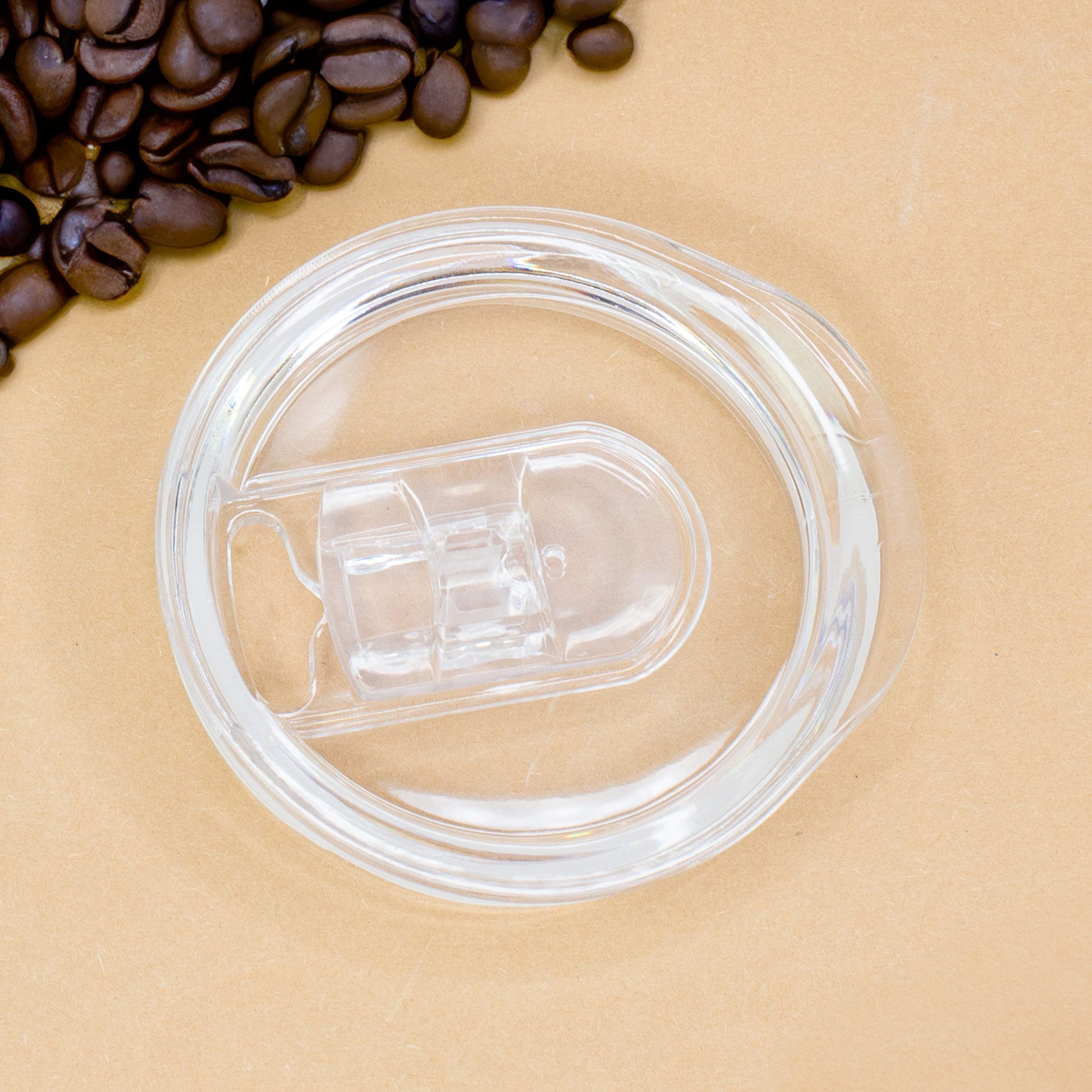Transparenter Deckel mit Schiebeverschluss für Thermobecher, daneben Kaffeebohnen