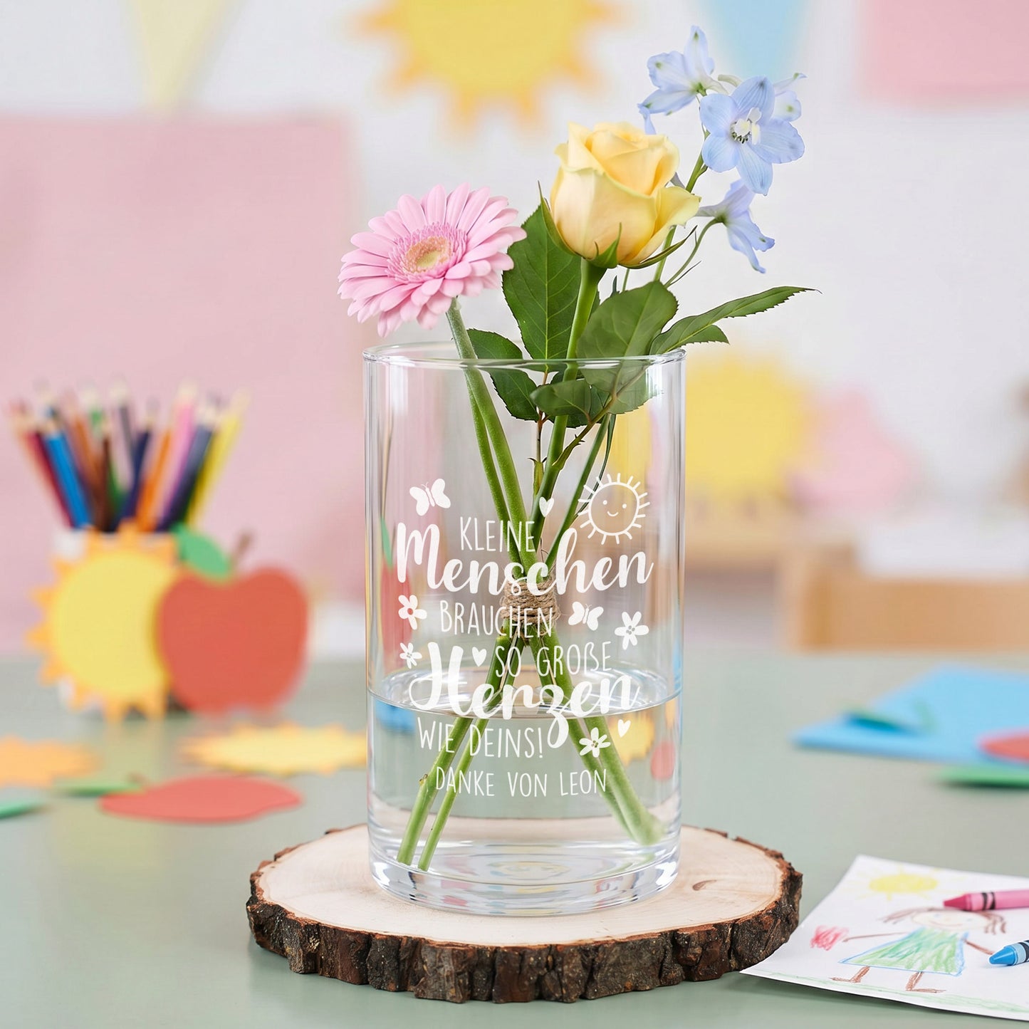 Glasvase mit Gravur und Wunschtext Danke von Leon, dekoriert mit Blumen als Geschenk für Erzieherin