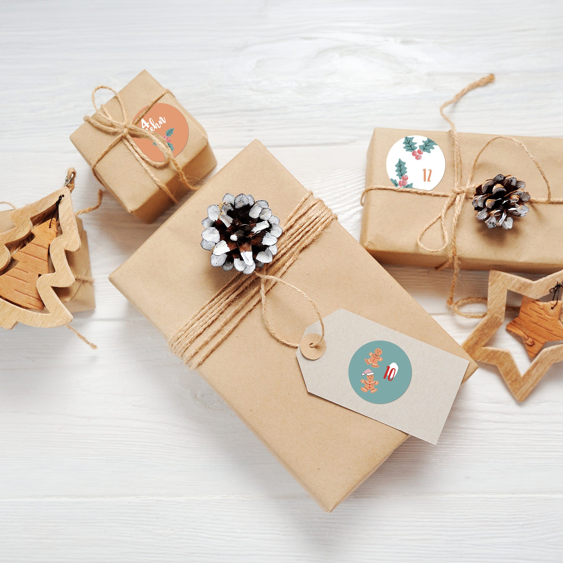 Geschenkverpackungen mit naturfarbenem Papier, dekoriert mit Adventskalender-Aufklebern in Rosa & Türkis