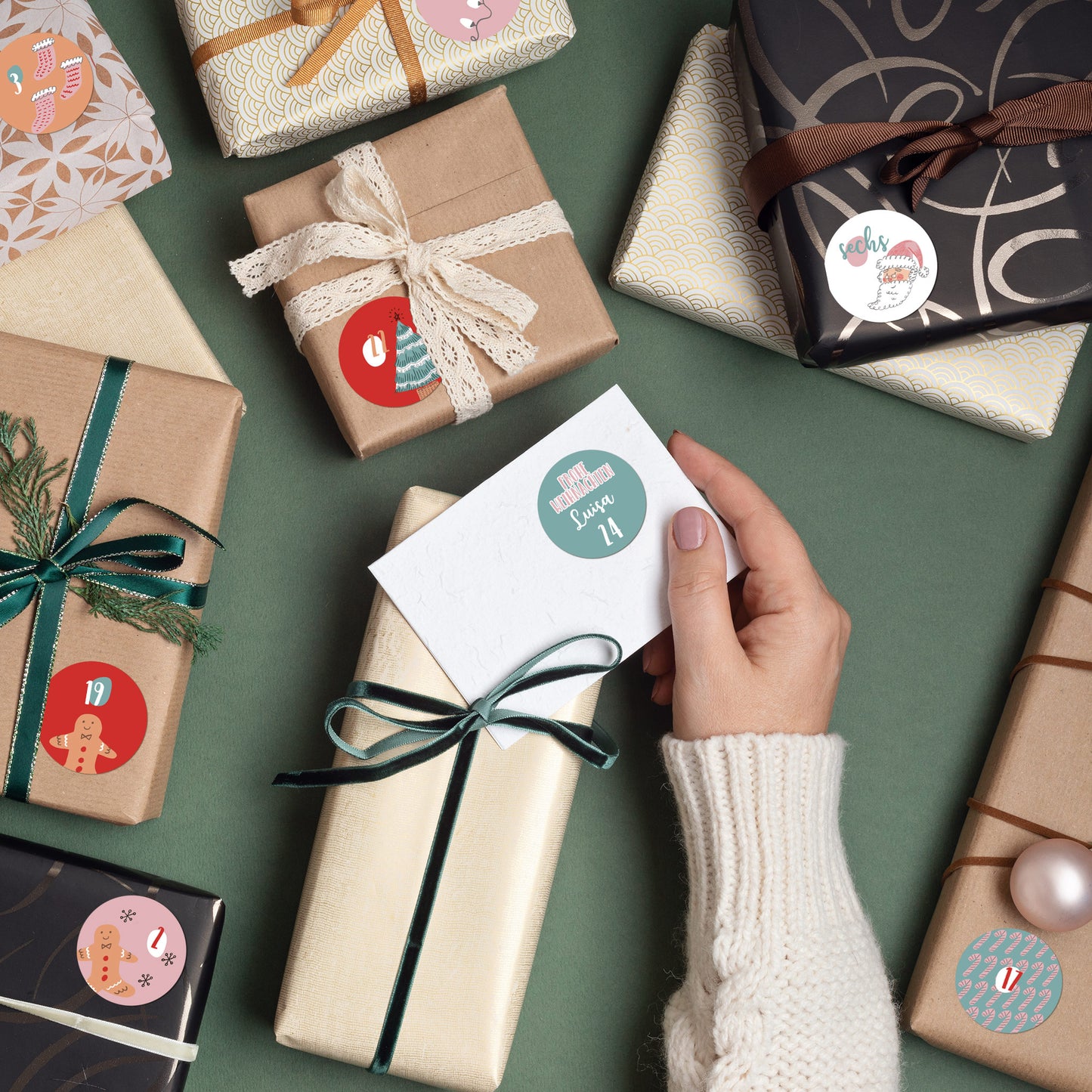 Hand hält ein Kärtchen mit Aufkleber „24“ und Name „Luisa“ – DIY-Adventskalender-Aufkleber in Rosa & Türkis