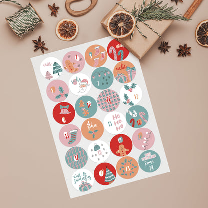 Bogen mit 24 runden Adventskalender-Aufklebern in Rosa & Türkis, nummeriert von 1 bis 24 dekoriert mit kleinen Geschenken und Zubehör